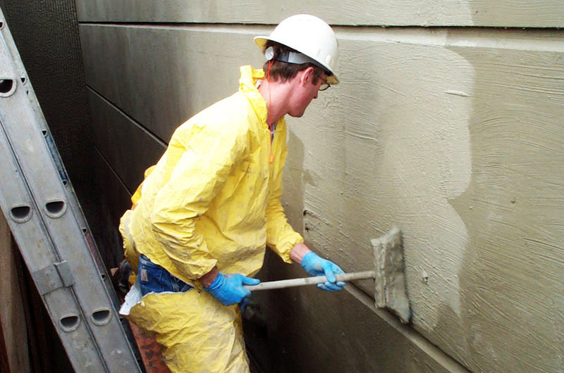 a man wearing a hard hat and protective gear holding a pipe